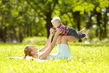 Cute little baby in the park with mother on the grass. Sweet bab